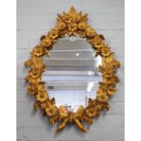 A late 19th century gilt framed mirror with extensive floral relief frame, 66cm wide x 92cm high.
