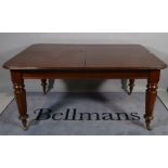 A Victorian mahogany extending dining table on tapering octagonal supports, two extra leaves,