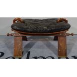 A mid-20th century brass inlaid hardwood camel stool with black leather seat.