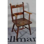 A 19th century beech and elm seated open armchair with bullseye back on turned supports,