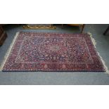 A Kashan rug, Persian, the indigo field with a madder medallion, matching spandrels,