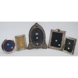 A silver mounted shaped oval photograph frame, with floral and scroll embossed decoration,