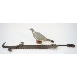 An early 20th century painted tin decoy pigeon on a wooden plinth, 35cm,