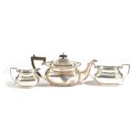 A silver three piece tea set, comprising; a teapot having black fittings,
