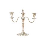 A silver three light table candelabra, the central stem raised on a shaped oval base,