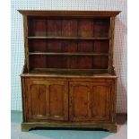 A late 19th century Continental pine kitchen dresser with two tier plate rack over cupboard door