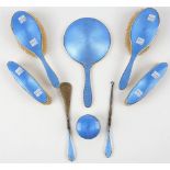 A lady's silver and blue enamelled part dressing set, comprising; a hand mirror, two hair brushes,