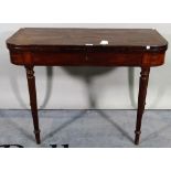 A Regency mahogany and ebony strung fold over tea table on reeded tapering supports.