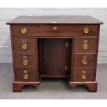 An 18th century mahogany kneehole writing desk with seven drawers about the cupboard on bracket