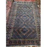 An Afghan Beluche rug, the dark madder brown field with hooked diamond vine design,