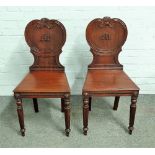 In the manner of Gillows; a pair of early 19th century mahogany hall chairs,