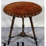 A Victorian parcel gilt ebonised circular occasional table, on three fluted supports,