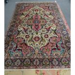 A Tabriz carpet, Persian, the ivory field with a pink medallion, with four palmettes,