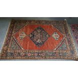 A Fereghan rug, Persian, the plain madder field with an indigo diamond filled with flowers,