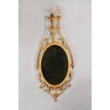 A George III gilt framed wall mirror, with stylized urn crest above oval mirror plate,