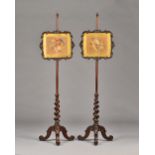 A pair of Victorian rosewood pole screens on barleytwist columns and three scroll supports,