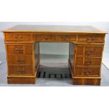 A 20th century mahogany pedestal desk with nine drawers about the knee and green leather inset top,