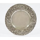 A shaped circular large dish, the wide border with floral, foliate and scroll embossed decoration,