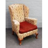 A George II style wingback armchair, on shell capped cabriole supports, 83cm wide x 109cm high.