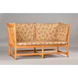 After Borge Mogensen; a beech framed spoke back sofa, 168cm wide x 87cm high. Illustrated.