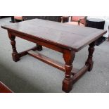 A 17th century style oak refectory table, the cleated plank top on turned supports,