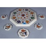 A marble and specimen stone inlaid octagonal table mat and five similar coasters, (6).