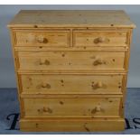 A 20th century pine chest of two short and three long graduated drawers, resting on a plinth base,
