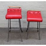 Two mid-20th century lacquered brass and steel bar stools on played supports,