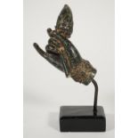 A patinated metal hand, cast holding a flower, probably Indian, 19th century,