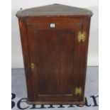 An 18th century and later oak hanging corner cupboard, 59cm wide x 91cm high.