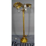 A 20th century gold painted metal standard lamp, the three glass shades with leaf decoration,