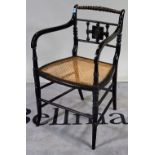 An early 19th century ebonised open armchair, with bobbin turned crest rail and splayed supports,