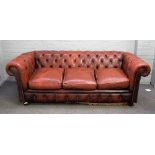 A 20th century button back brown leather upholstered Chesterfield sofa, on turned feet,