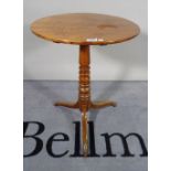 A 19th century mahogany tripod table with turned column and three outswept supports.