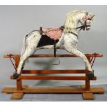 An early 20th century white and grey painted rocking horse on pine stand, 115cm wide x 96cm high.