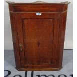 An 18th century oak and mahogany hanging corner cupboard, 69cm wide x 96cm high.