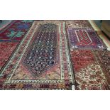 A Turkish prayer rug, madder mehrab with two plants, an indigo leaf border,