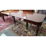 An early 19th century mahogany extending dining table, with split bobbin mounted frieze,