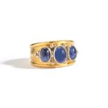 An 18ct gold and sapphire three stone ring, collet set with a row of three oval cabochon sapphires,