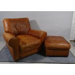 A 20th century hardwood framed low armchair with tan leather upholstery,