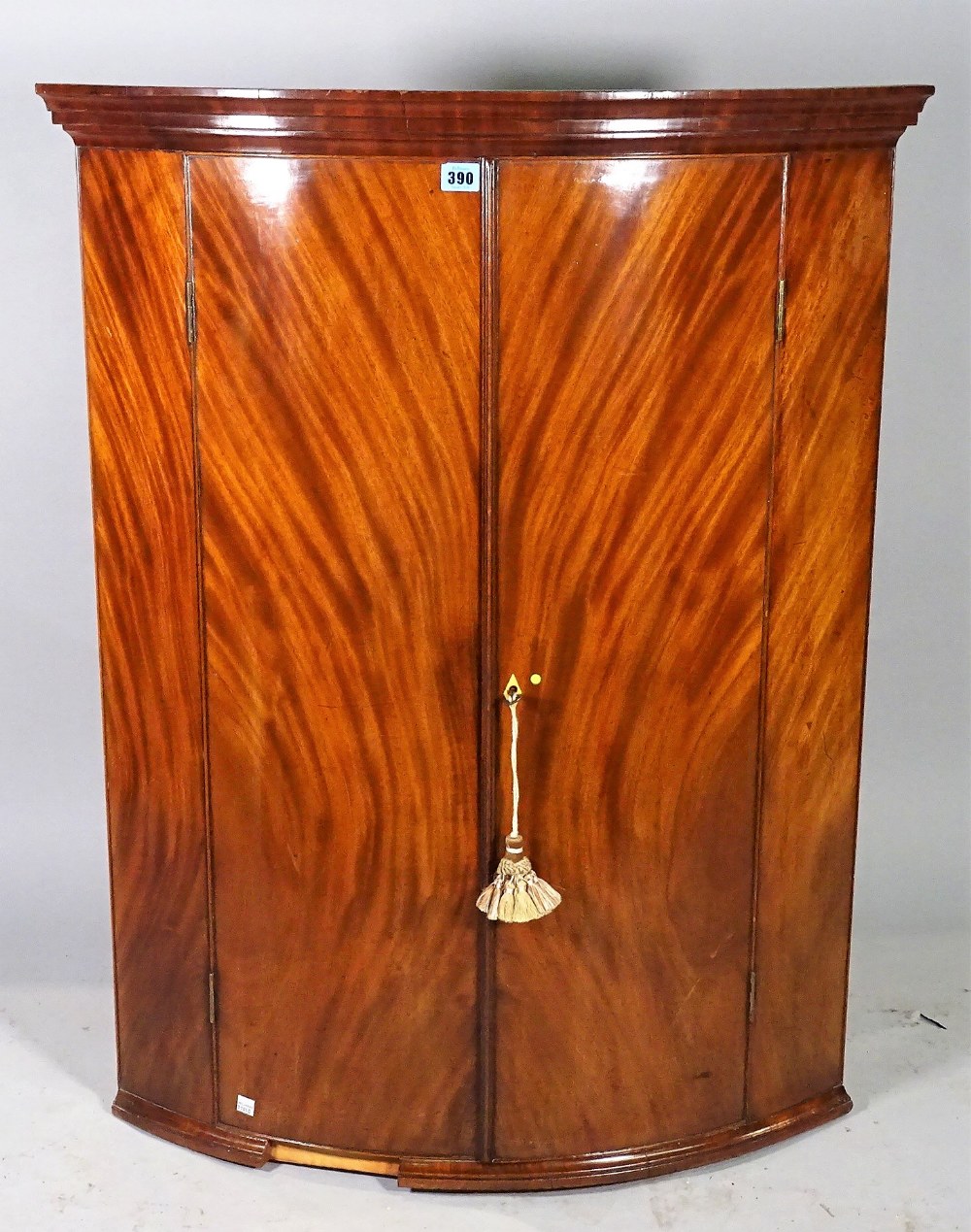 An 18th century mahogany bowfront hanging corner cabinet, 77cm wide x 100cm high.