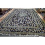 A Kashan carpet, Persian, the indigo field with a pale indigo roundel,