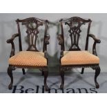 A pair of late 19th century mahogany open armchairs, of mid-18th century design, on scroll supports,
