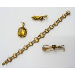 A gold brooch, designed as a foxes mask, a riding crop and a hunting horn, a gold brooch,