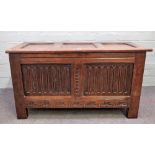 An 18th century oak coffer, with triple panel lid and carved double panel front, on stile feet,