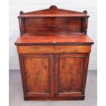 An early Victorian mahogany chiffonier, the ledge back over frieze drawer and pair of cupboards,