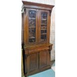 A Victorian walnut bookcase cabinet with moulded arch glazed doors on plinth base,