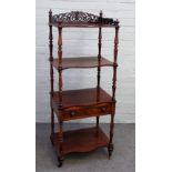 A Victorian rosewood what-not, with fret carved gallery over four serpentine tiers, one with drawer,