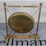 An early 20th century brass and oak framed dinner gong, 58cm wide x 74cm high.