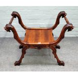 A 19th century Italian walnut 'X' frame stool, with beast head finial's and paw feet,